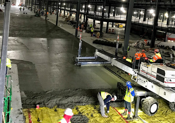 B&B Concrete Placement Inc workers lay a concrete foundation inside a new Amazon fulfillment center in Romulus Michigan