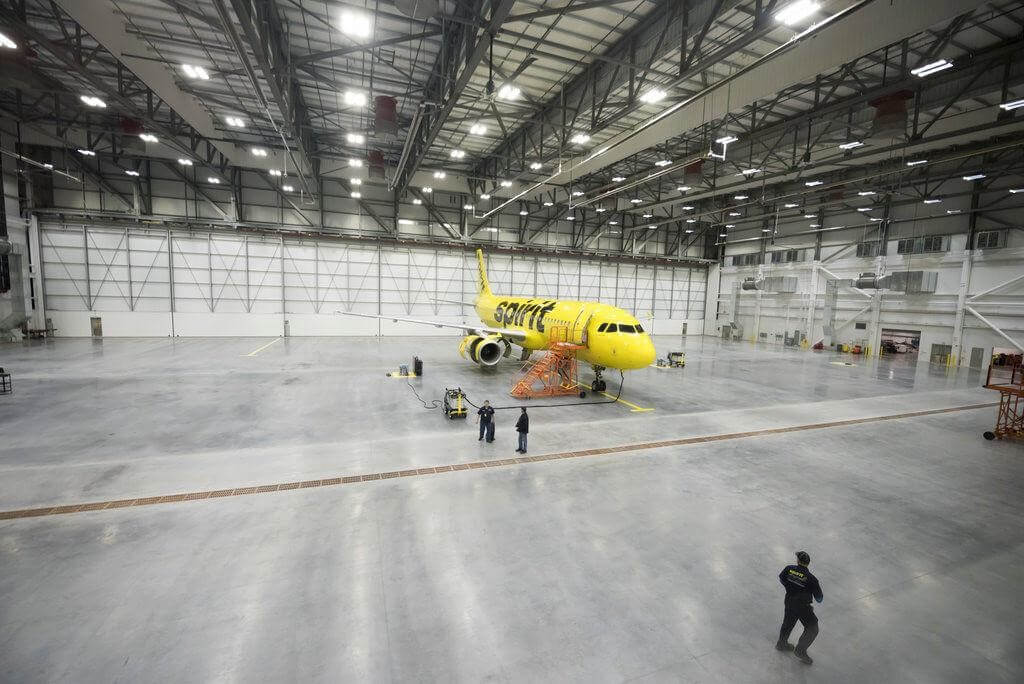 A yellow Spirit airlines plane in their new hangar