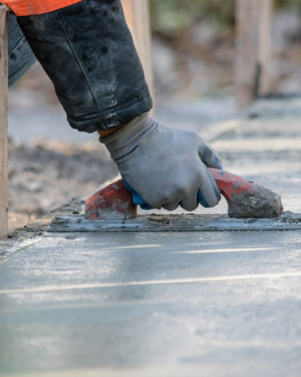 CAT backhoes digging or cleaning a flat ground surface to prep it for concrete